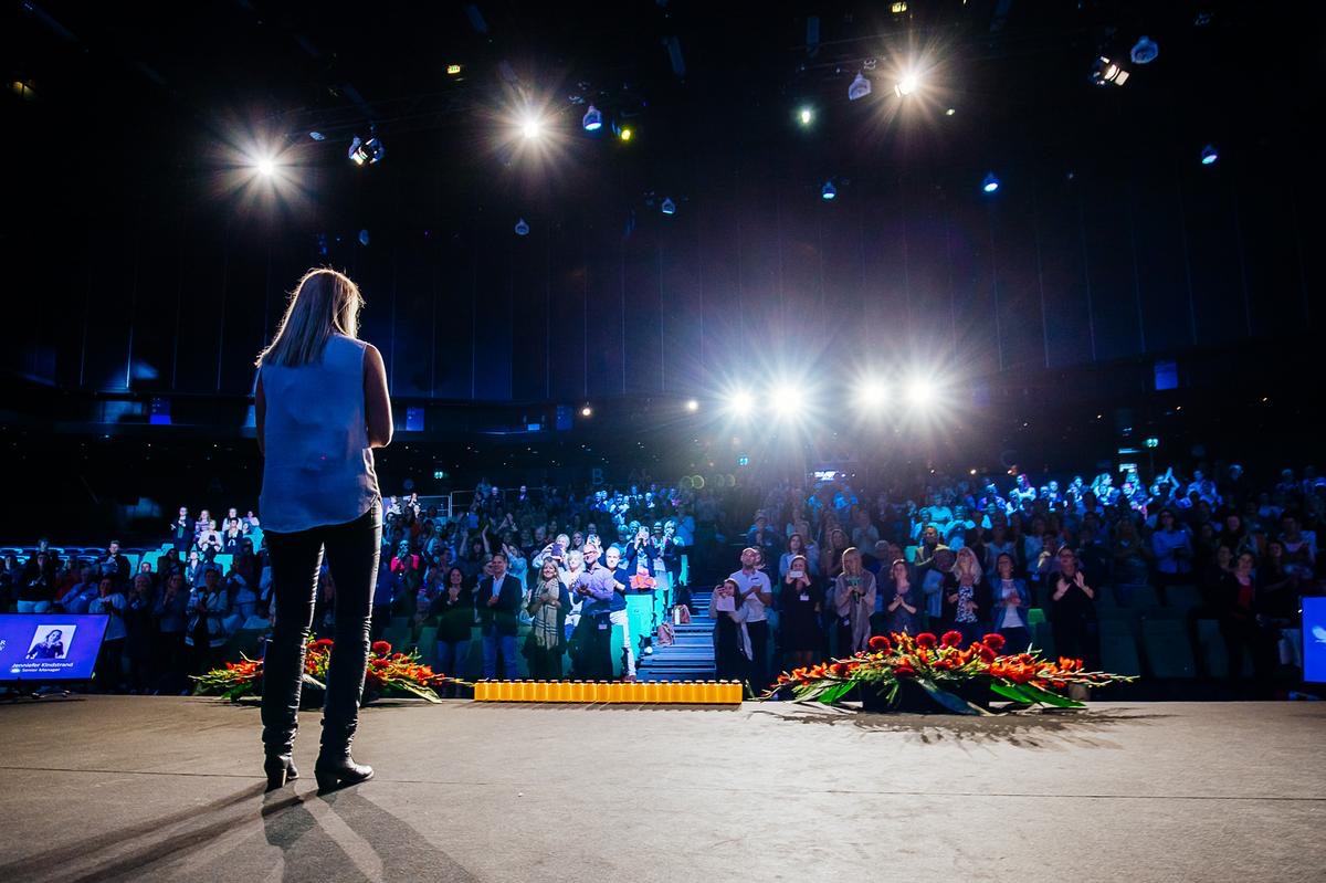 Jenniefer Kindstrand på scen inför en fullsatt publik som applåderar.